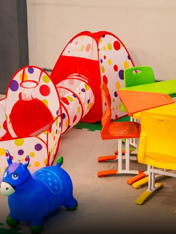 Espaço Kids com brinquedos e mesinhas coloridas