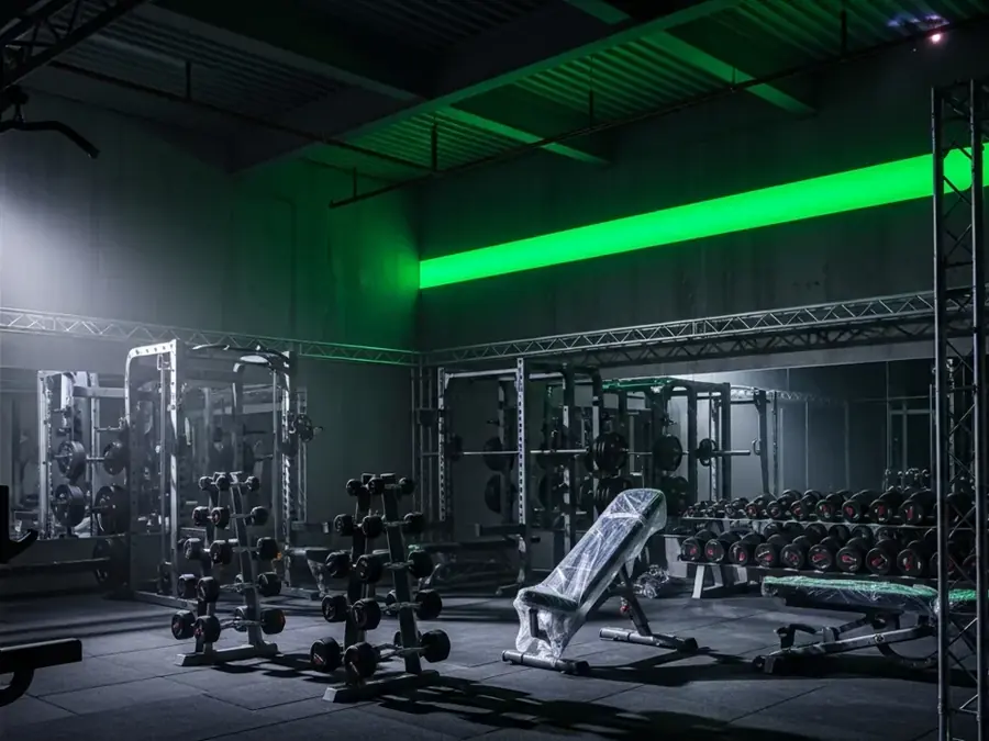 Salão de musculação da unidade Jacarandás, com faixa de LED verde na parede